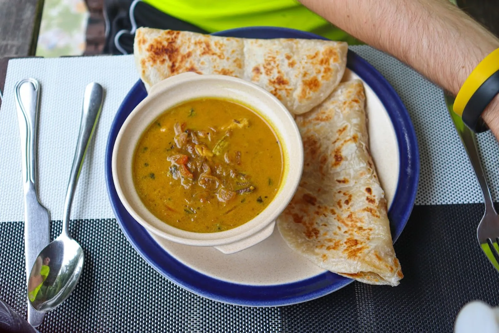 A bowl of curry served with freshly griddled roshi flatbread at Basilico Restaurant, Ukulhas Island, Maldives