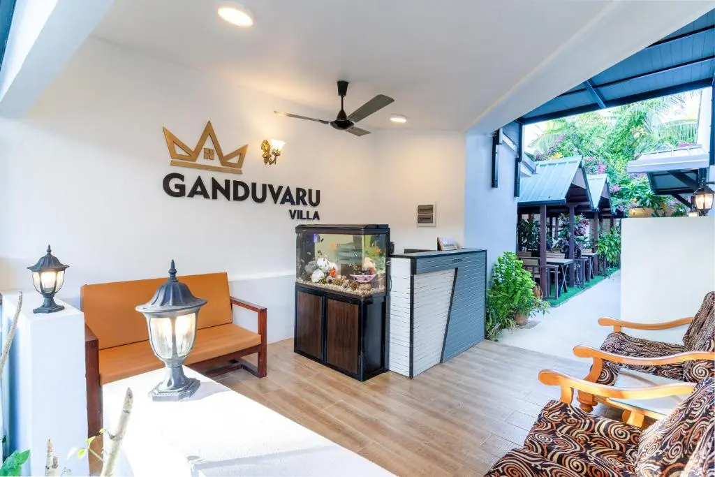 Covered lounge terrace with branded wall at Ganduvaru Villa, Ukulhas Island, Maldives