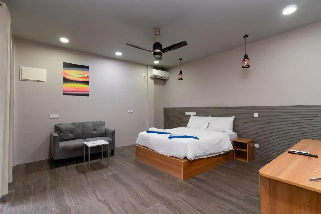 Guest room with double bed and sofa seating at Island Villa, Ukulhas Island, Maldives