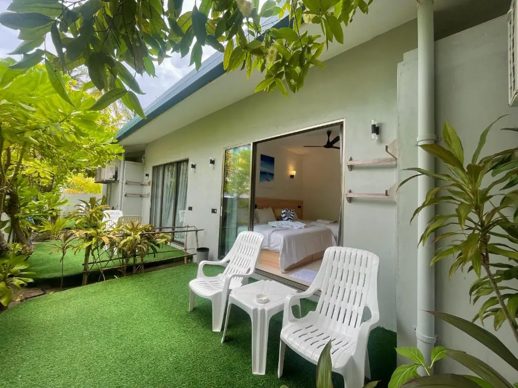 Garden terrace with loungers outside a guest room at La Solara Villa, Ukulhas Island, Maldives