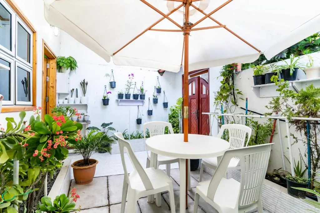 Plant-filled courtyard patio with outdoor dining table at Maafolhey Han'dhaan, Ukulhas Island, Maldives