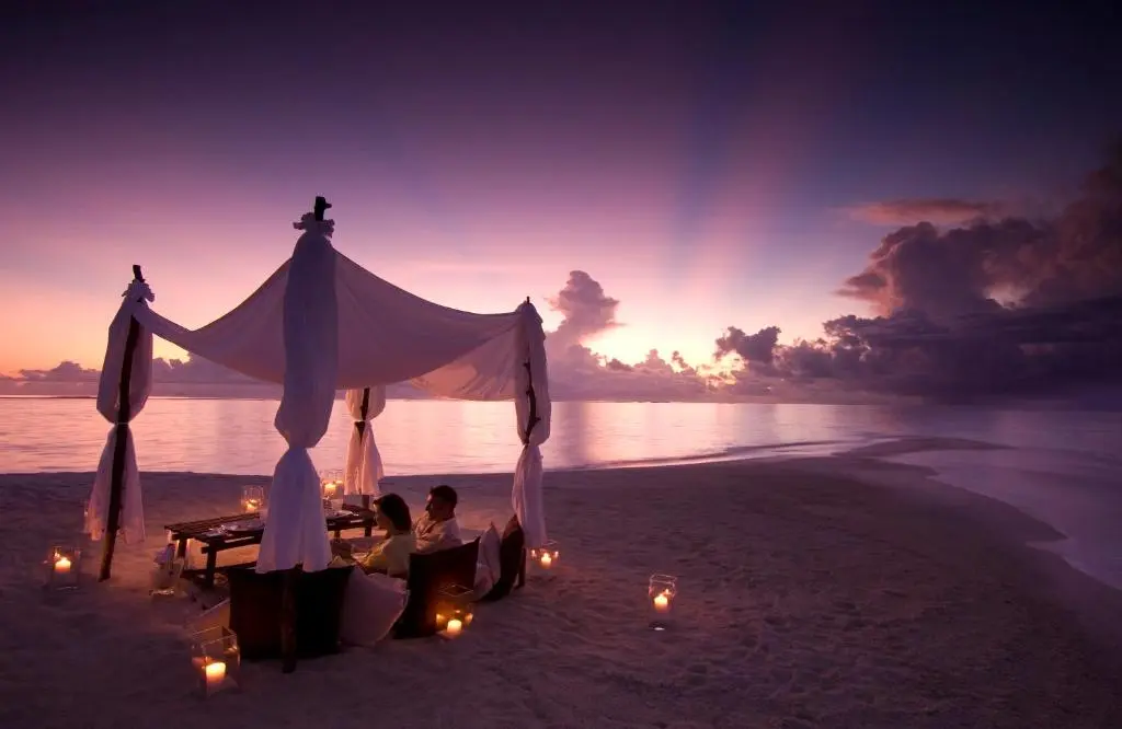 Private sunset beach dinner set up on the sand at Nala Veli Beach and Spa, Ukulhas Island, Maldives