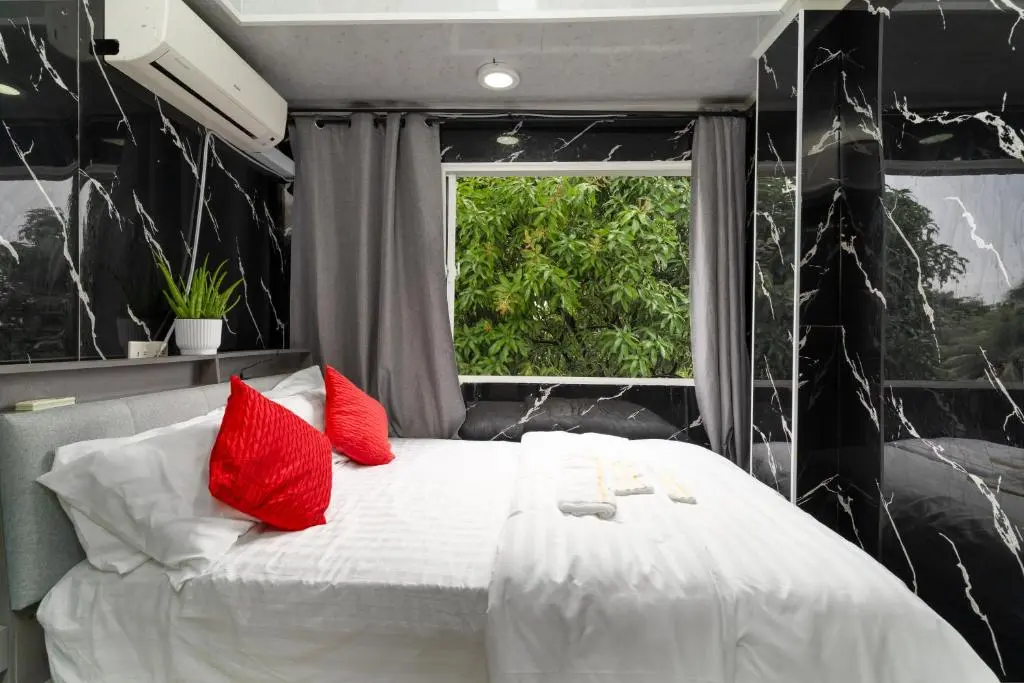 Guest room with dark marble-look walls and red accent pillows at Naseema Hiya Central Ukulhas Residences, Ukulhas Island, Maldives