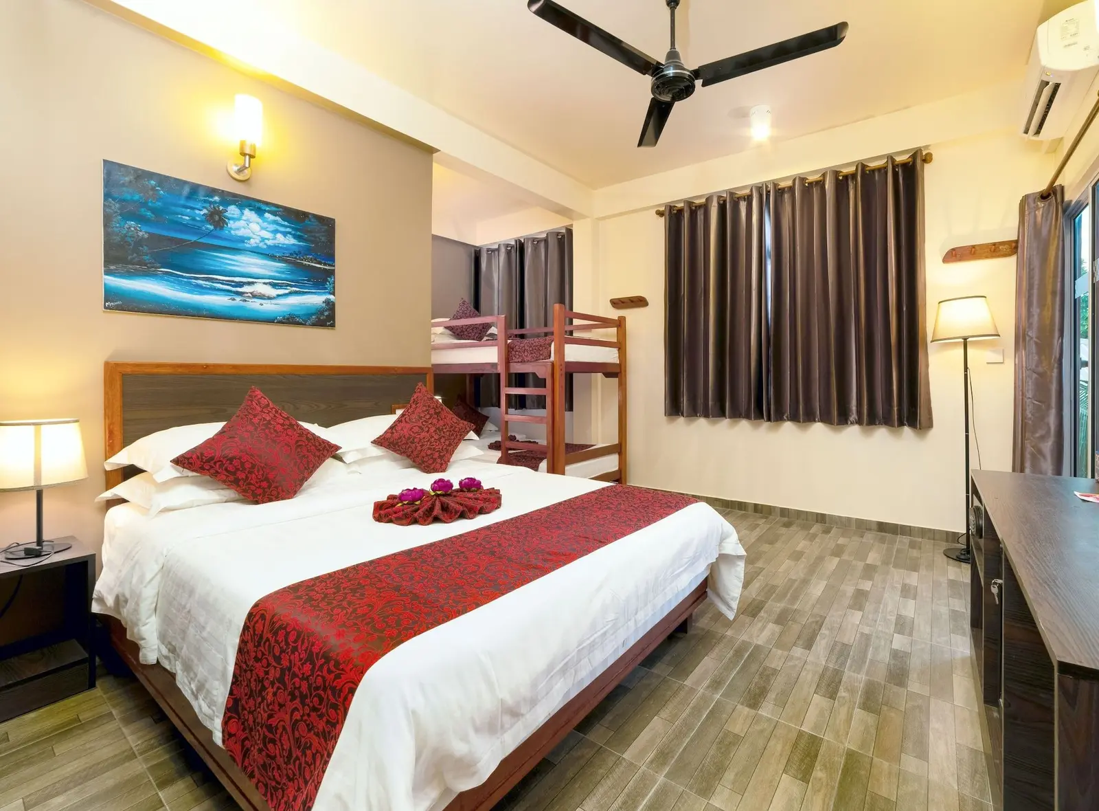 Guest room with double bed and red bedding accents at Paguro Beach Inn, Ukulhas Island, Maldives