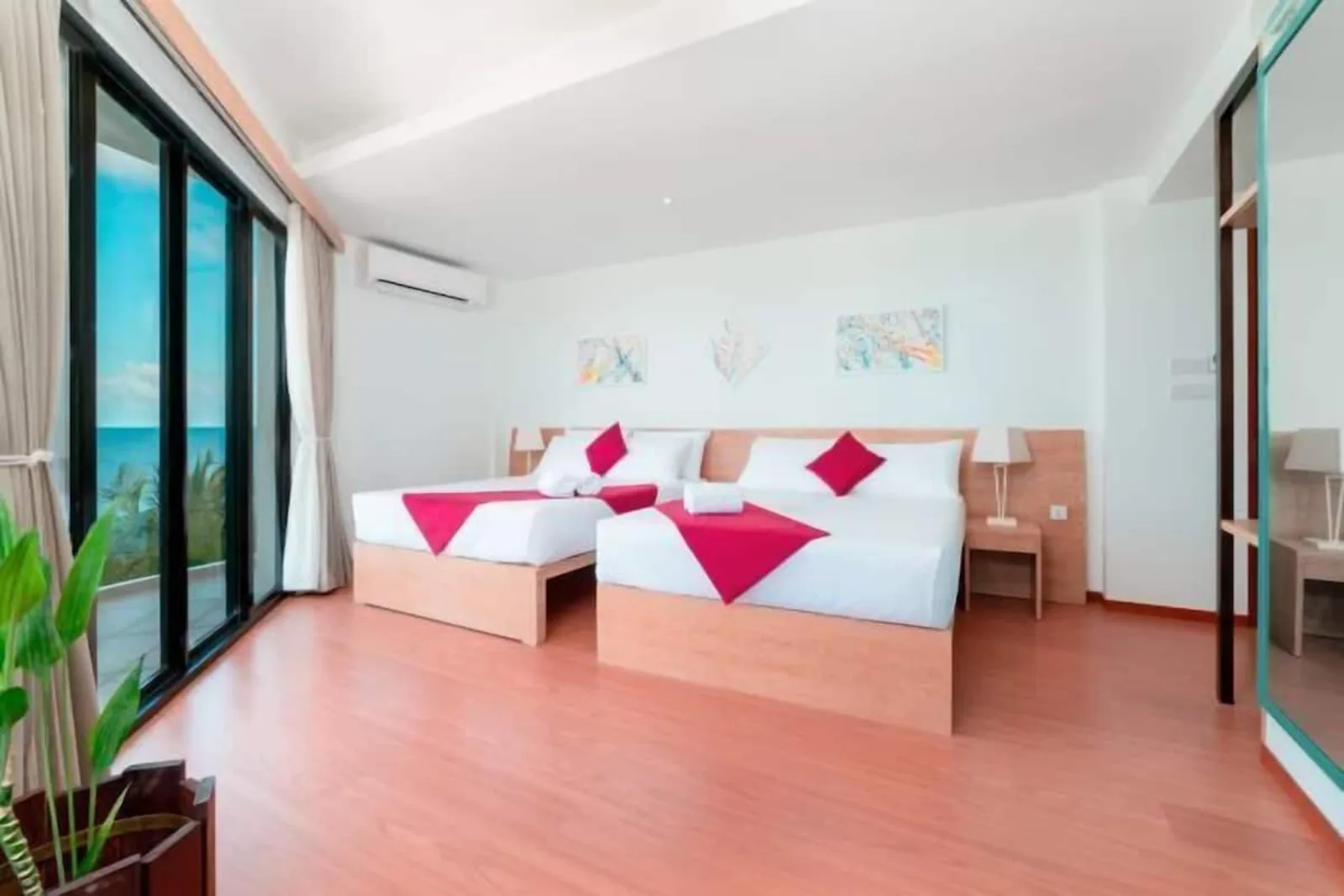 Spacious sea-view room with floor-to-ceiling windows and two beds at Ranthari Hotel & Spa, Ukulhas Island, Maldives