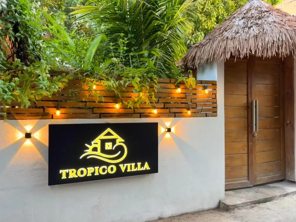 Thatched entrance with lit property sign at Tropico Villa, Ukulhas Island, Maldives