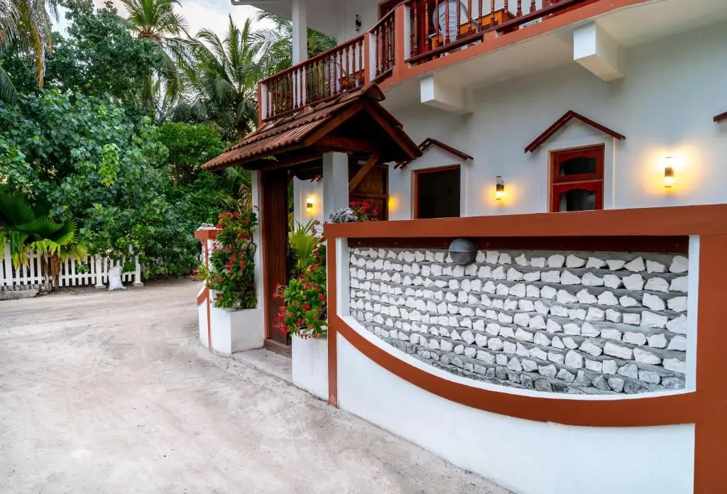 Guesthouse exterior with timber balconies on a sandy lane at Ukulhas View, Ukulhas Island, Maldives